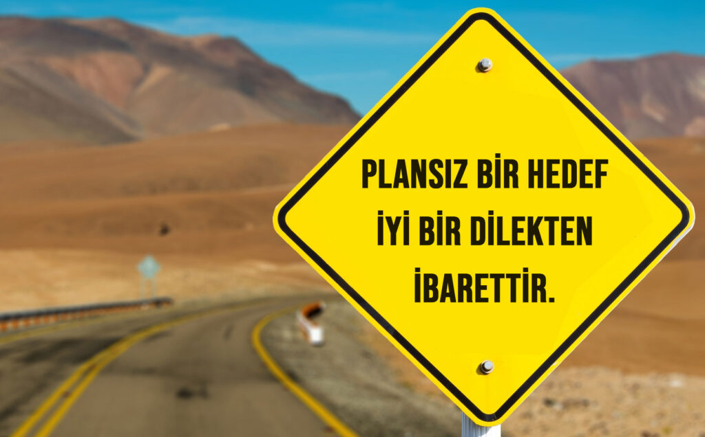 Hedef nedir, hedef ne demek konusuna işaret eden, plansız bir hedef iyi bir dilekten ibarettir yazılı sarı bir tabela.